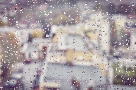 Raindrops on a window glass, color toning applied, selective focus.