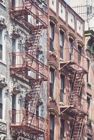 Manhattan old residential buildings with fire escapes, color toning applied, New York City, USA.の写真素材