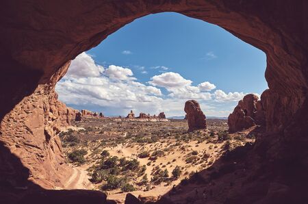 Natural arch window in Arches National Park, color toned picture, Utah, USA.