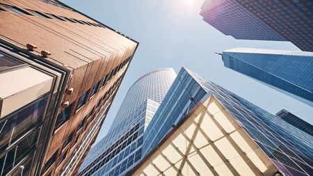 Looking up at Manhattan skyscrapers against the sun, color toning applied, New York City, USA.の写真素材