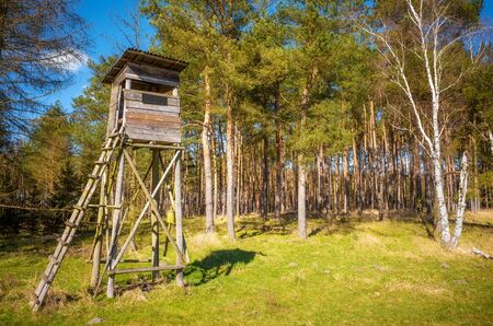 Wooden elevated deer hunting blind at the edge of a forest and field.の写真素材