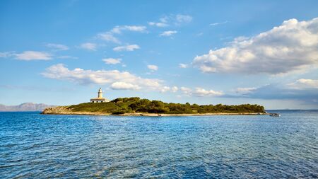 Island with Alcanada Lighthouse (Faro de Alcanada), Mallorca, Spain.