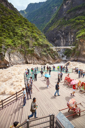 Jizha, China - September 24, 2017: People at the Tiger Leaping Gorge rough waters viewpoint. It is part of the Three Parallel Rivers of Yunnan Protected Areas World Heritage Site.のeditorial素材