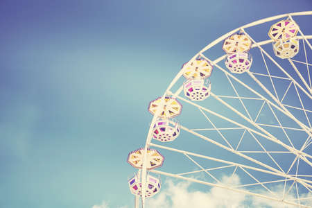 Retro toned picture of a Ferris wheel on a sunny day.の写真素材