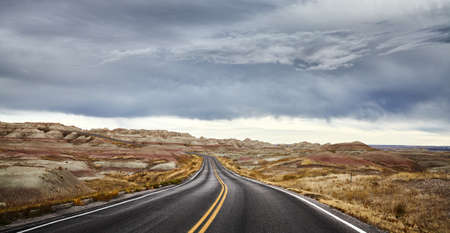 Stormy clouds over road in Badlands National Park, travel concept, South Dakota, USA.