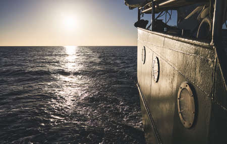 Stern of an old ship at sunset, travel or homesickness concept.の写真素材