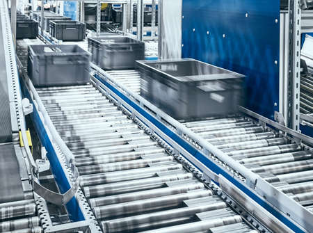 Modern roller conveyor system with boxes in motion, shallow depth of field.の写真素材