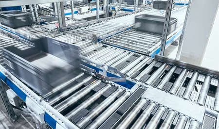 Modern roller conveyor system with boxes in motion, shallow depth of field.の写真素材