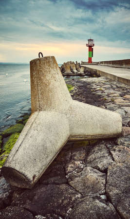 Concrete tetrapod breakwater on a pier in Swinoujscie at sunset, color toned picture, Poland.の写真素材