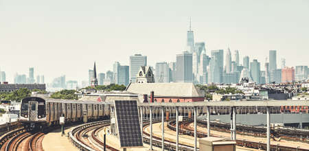 New York subway train with Manhattan skyline in background, color toned picture, USA.の写真素材