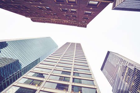 Looking up at modern and old buildings in New York City, color toning applied, USA.