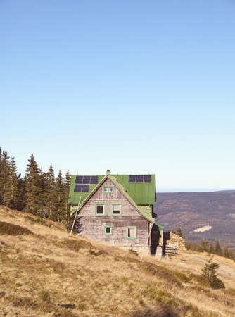 Retro toned picture of mountain hut with solar panels on roof.の写真素材