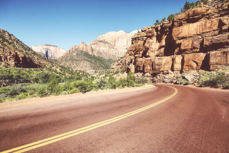 Asphalt road in Zion National Park, retro color toning applied, Utah, USA.