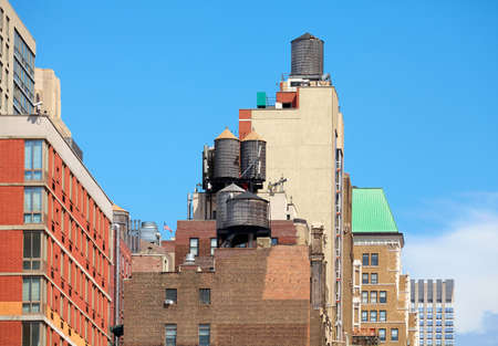 Water towers on roofs of New York buildings on a sunny day, USA.