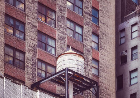Water tower on a roof of an old building in Manhattan, color toning applied, New York City, USA.の写真素材