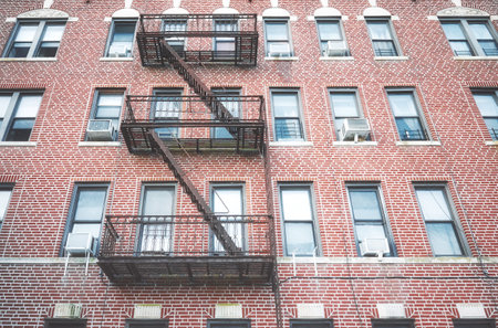 Old red brick building with iron fire escape, New York City, USA.