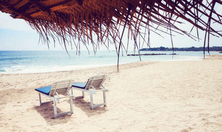 Sunbeds on a tropical beach, color toned picture.の写真素材
