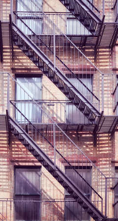 Old brick building with iron fire escape, color toning applied, New York City, USA.の写真素材
