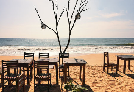 Tables with chairs on a tropical sunny beach, retro color toning applied.の写真素材