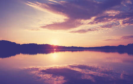 Scenic sunset over lake, color toning applied.の写真素材