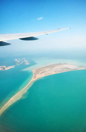 Wing of a plane above the sea, travel and transport industry concept.の写真素材