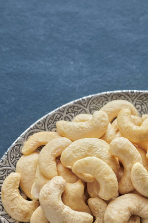 Cashew nuts on a silver plate, selective focus.