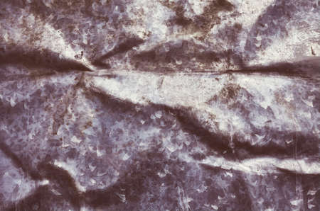 Retro color toned picture of an old creased metal sheet, dark abstract grunge background or texture.の写真素材