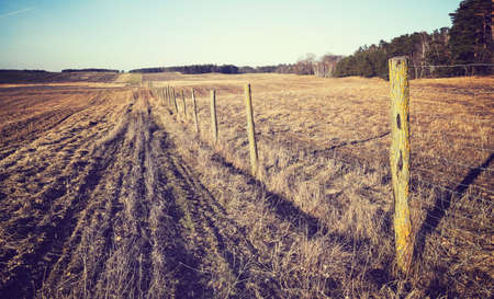 Agricultural field with wire fence, color toning applied.の写真素材