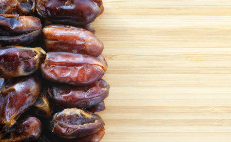 Close up picture of dried dates on a wooden background, selective focus.の写真素材