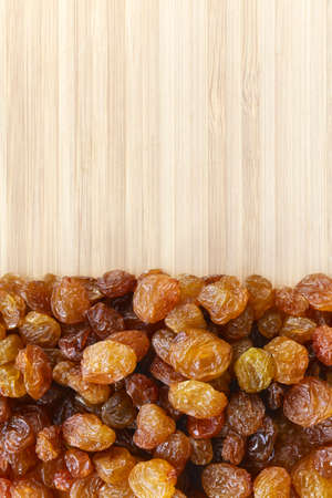 Close up picture of small raisins on a wooden background, selective focus.の写真素材