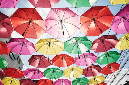 Hanging colorful umbrellas against the sky.