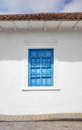 Street view of an old colonial building facade with blue window, architecture background, Cuenca, Ecuador.の写真素材