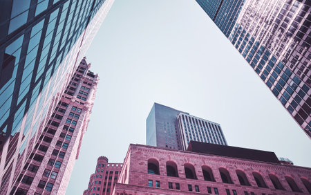 Looking up at New York City skyscrapers, color toning applied, USA.