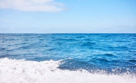 Blurred photo of sky and sea with splashing water, travel background.