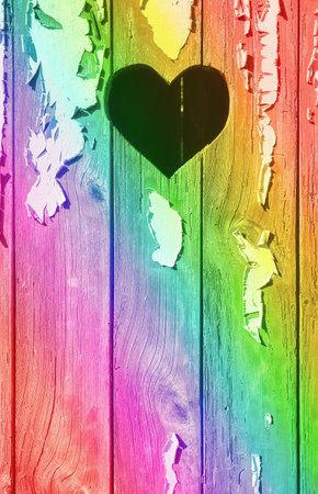 A heart shape cut out of a wooden board with peeling paint.の写真素材