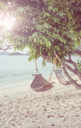 Hammocks on the beach of a tropical island, color toning applied, Philippines.の写真素材
