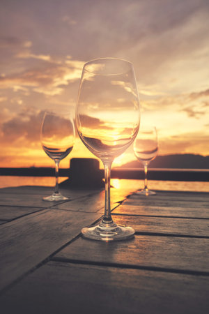 Empty wine glasses placed on a table at sunset, selective focus.