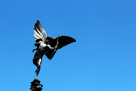 LONDON, UK - AUGUST 2018: Eros statue with bow and arrow against blue sky in Piccadilly Circus