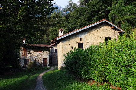 Path and old houses in a rural village surrounded by a forestのeditorial素材