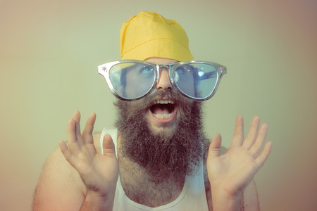 A wacky excited bearded man puts his hands in the air with a smileの写真素材