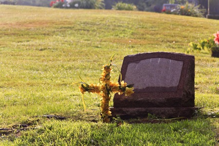 Anonymous grave with flower cross in graveyardの写真素材