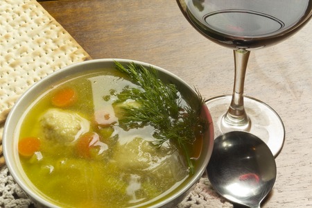 Delicious Matzoh ball soup with crackers wine and dillの写真素材