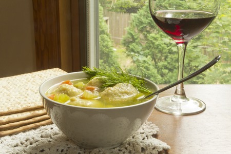 Delicious Matzoh ball soup with crackers wine and dillの写真素材