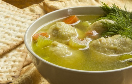 Delicious Matzoh ball soup with crackers wine and dillの写真素材