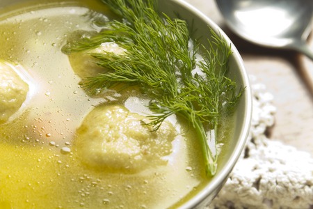 Delicious Matzoh ball soup with crackers wine and dillの写真素材