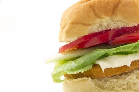 A fresh chicken patty sandwich with tomato, lettuce, and mayo on a bunの写真素材