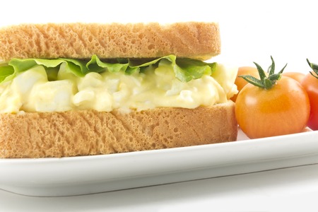 Health conscious egg salad sandwich on white bread with cherry tomatoesの写真素材