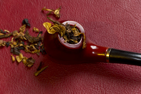 Pipe, tobacco, cigarettes, cigars, smoking, etc. on red leather background