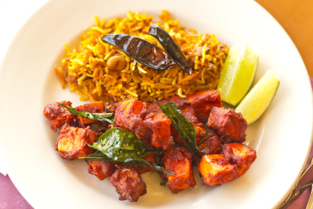 Crispy spicy Kadai Paneer Tofu with tamarind rice and lime wedgesの写真素材