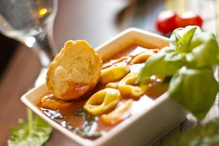 Hearty tortellini tomato soup with spinach and basilの写真素材